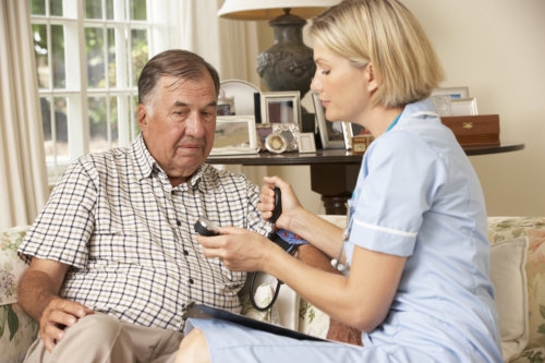 retired senior man gaving health check with nurse at home